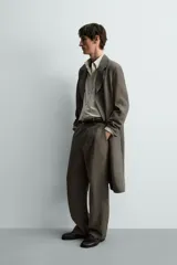 Pantalón straight fit color verde militar, confeccionado en lino, con cintura con trabillas, cierre frontal con cremallera y botón, y bolsillos laterales.