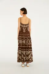 Vestido largo marrón con estampado estilo paisley y mariposas en tonos crudos, de corte fluido, con tirantes finos y diseño escalonado en la falda.