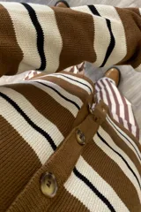 Saco tejido a rayas horizontales marrones, beige y negras, con cuello en V y cierre frontal con botones.