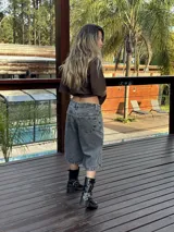 Bermuda de jean gris oscuro con lavado gastado, corte ancho y largo a la rodilla.