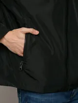 Campera ligera Calvin Klein de corte regular, confeccionada en tejido técnico resistente al viento y la llovizna. Presenta cierre frontal con cremallera, capucha ajustable con cordones, bolsillos laterales con cierre y puños elásticos.