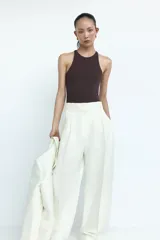 Body colaless de punto suave y color marrón oscuro, con diseño sin mangas, escote alto y espalda nadadora. Cuenta con botones a presión ocultos en la entrepierna y frente forrado.