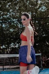 Top deportivo verde con breteles finos y contorno blanco.