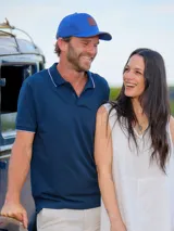 Remera tipo polo negra de algodón, con cuello y borde de mangas con línea blanca.