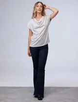 Blusa de mujer Cable & Gauge color beige claro, confeccionada en tejido lurex con textura plisada vertical. Presenta un escote drapeado tipo cuello volcado y mangas cortas.