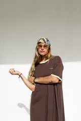 Vestido largo marrón con cuello redondo y mangas cortas con ribete amarillo. Estampado frontal con letras en color crema.