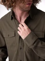 Camisa de manga larga color verde militar con bolsillos frontales con solapa y botones, confeccionada con mezcla de tencel.