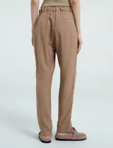 Pantalón de vestir color verde esmeralda, de corte recto con bolsillos laterales. Presenta botón y cierre en la parte delantera y pretina con elástico en la parte trasera.