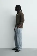 Pantalón jeans de corte recto y ajuste holgado, confeccionado en denim de algodón rígido. Presenta diseño clásico de cinco bolsillos, cierre frontal con cremallera y botón, con un acabado de lavado claro.
