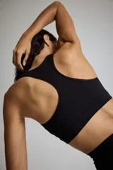 Top deportivo negro con espalda deportiva y soporte medio.