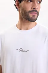 Remera blanca de manga corta y corte holgado, con cuello redondo y estampa pequeña en el pecho con la inscripción "Portofino".