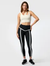 Top deportivo color blanco con diseño asimétrico de aberturas ovaladas en el escote, confeccionado en tejido con tecnología Aloe Vera.