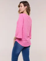 Blusa rosada con textura en relieve de motivos florales, cuello redondo con pequeña muesca y mangas tres cuartos.