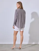 Camisa celeste con rayas verticales blancas, de corte clásico, cuello a la base, escote en V y cierre frontal con botones.