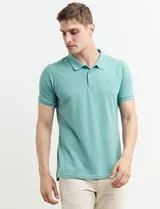 Remera polo azul marino de manga corta, con cuello y tapeta de dos botones. Presenta aberturas laterales en el dobladillo.