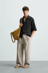 Camisa de corte relajado confeccionada en tejido mezcla de lyocell, con cuello solapa, manga corta y cierre frontal con botonadura oculta.