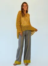 Pantalón gris de lino con corte palazzo y detalle de costuras amarillas en los laterales y en el ruedo.