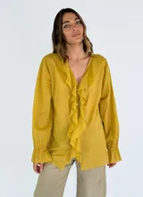 Camisa celeste de mangas 3/4 con volados en el frente y cuello en V.