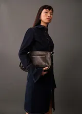 Falda corta de jean en color azul oscuro, con diseño entallado, cinco bolsillos, trabillas para cinturón y una abertura frontal en el bajo.