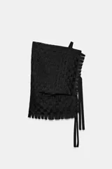 Top asimétrico de diseño trenzado color negro, con un solo tirante y lazadas laterales.