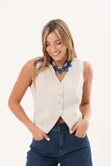 Chaleco beige de lino con escote en V, sin mangas y cierre frontal con botones nacarados.