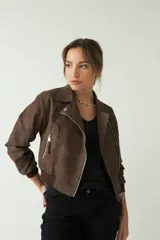 Campera corta color marrón chocolate, con textura tipo gamuza, cuello clásico, cierre frontal asimétrico con cremallera metálica y bolsillos laterales con cremallera.