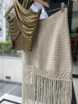 Falda tejida a mano en crochet, color crudo, con flecos en el ruedo y abertura lateral.