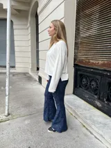 Pantalon oxford de tiro alto, confeccionado en tejido térmico de color azul con efecto desgastado. Presenta un corte ajustado en la parte superior y acampanado desde la rodilla hacia abajo.