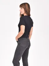 Remera ajustada color azul grisáceo, con cuello redondo y ribete en contraste en el cuello y las mangas. Presenta un estampado frontal con texto que dice "Beverly Hills Tennis Club Est. 1985" y un gráfico de una raqueta de tenis y una copa de vino cruzadas.