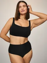 Bralette negro de escote cuadrado y tirantes anchos, confeccionado en tela scuba suave y elástica.