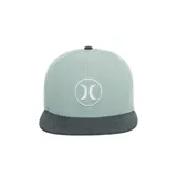 Gorra tipo trucker con visera plana, cuerpo en color verde menta y visera en tono gris oscuro melange. Presenta el logotipo bordado de la marca en el panel frontal dentro de un círculo blanco.