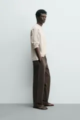 Camiseta de manga larga con cuello redondo, confeccionada en algodón compacto y pesado, con diseño de corte relajado y costuras decorativas en el cuello.