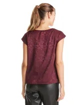 Blusa de satén labrado con diseño de jacquard tono sobre tono, cuello volcado y manga corta con hombro caído.