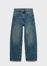 Jeans de tiro medio y corte barrel con diseño de ojales metálicos distribuidos por toda la prenda. Cuenta con cinco bolsillos, cierre de botón y cremallera, y trabillas para cinturón.