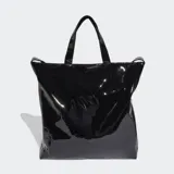 Bolso shopper Adidas de diseño minimalista en material sintético efecto charol brillante color negro. Cuenta con doble asa de mano y correas largas para llevar al hombro, cierre principal y logo del trifolio estampado en color blanco en la parte frontal.
