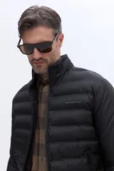 Campera puffer de nylon color negro, con diseño minimalista, cuello alto y cierre frontal. Presenta el logo de la marca Brooksfield bordado en el pecho y bolsillos laterales con cierre.