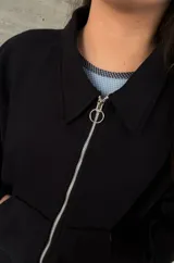 Buzo celeste de corte holgado, con cuello polo y cierre frontal parcial.