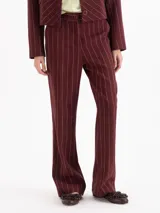 Pantalon de sastreria color bordeaux con diseño de rayas finas verticales blancas, de tiro alto y pierna recta.