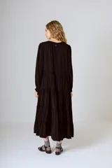 Vestido midi negro con corte en la cintura y falda amplia con volados.