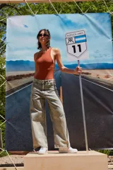 Body color marrón oscuro, confeccionado en microfibra, con escote delantero y trasero cerrado, cuerpo embolsado y gancho corsetero regulable en la entrepierna.