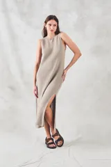 Vestido midi sin mangas, confeccionado en tejido de punto de algodón con textura tipo waffle. Presenta un corte recto, cuello redondo y aberturas laterales pronunciadas en el ruedo.
