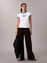 Remera Calvin Klein ajustada de color blanco, con cuello redondo y ribetes en las mangas de color verde oscuro. Presenta un estampado gráfico frontal con el texto "Calvin Klein 1968" en tono verde.