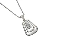 Dije de plata con piedra de la luna, con diseño geométrico de rectángulos redondeados concéntricos.