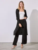 Cardigan largo plisado de satén color negro, con aberturas laterales.