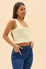 Top crop de tejido rib color amarillo claro, con escote redondo pronunciado y tirantes anchos.
