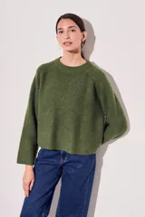 Sweater de lana color rojo, con cuello redondo, mangas largas y detalle de costura decorativa en los laterales.