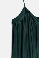 Vestido midi color morado oscuro, confeccionado en tejido satinado con efecto plisado o arrugado. Presenta escote en pico y tirantes finos ajustables. El calce es fluido y holgado.