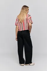 Babucha de calce relajado color negro, con cintura elastizada, cordón de ajuste y bolsillos laterales. Presenta un diseño de pernera amplia y cómoda.