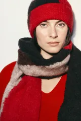 Bufanda de punto con diseño geométrico de bloques de color en tonos marrón, negro, beige y rojo. Confeccionada en una mezcla de fibras que incluye alpaca y lana.