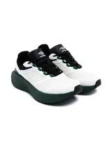 Championes Umbro modelo Gridlock para hombre, en combinación de blanco, negro y verde oscuro, con diseño aerodinámico y suela chunky.